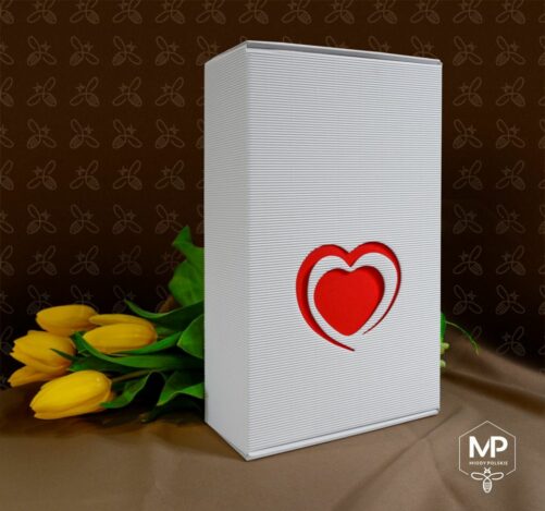białe pudełko prezentowe zdobione czerwonym sercem z okolicznościowym zestawem miodów, miodem pitnym, miodem kwiatowym, czekoladkami i sokiem