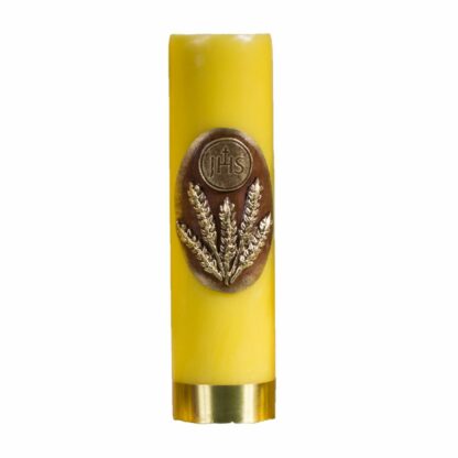żółta świeca ołtarzowa z ręcznie malowaną aplikacją - złote kłosy z emblematem IHS na brązowym tle; u dołu świecy złota opaska