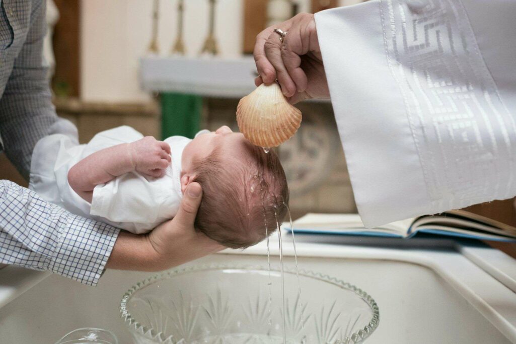 dziecko podczas chrztu swietego, polewane woda przez ksiedza
